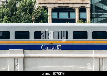Montreal, Canada - 14 agosto 2025: Vista ravvicinata dei vagoni ferroviari VIA Rail Canada con strisce gialle e blu nel centro di Montreal, che mostrano il wi Foto Stock