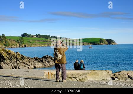 Persone che si rilassano al sole invernale sul fiume Helford, Cornovaglia, Regno Unito Foto Stock