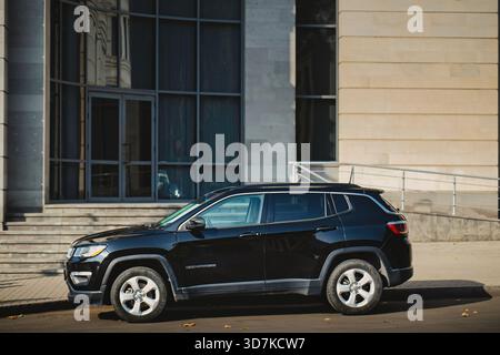 Erevan Armenia 11.20.2025. Una bussola nera Jeep è parcheggiata di fronte a un edificio. L'auto è parcheggiata su una strada e ha un grande finestrino sul davanti Foto Stock