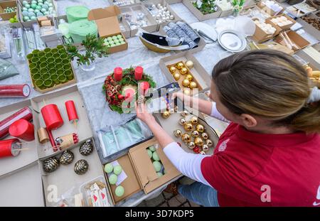 Lindenberg, Germania. 26 novembre 2025. Kathrin Herlein, fiorista di Gärtnerei Heinrich, crea una corona dell'Avvento. Il 30 novembre è il 1° Avvento. Ci sono molte interpretazioni diverse della corona dell'Avvento. Il simbolismo originale è l'aumento della luce come espressione della crescente attesa della nascita di Gesù Cristo. Crediti: Patrick Pleul/dpa/Alamy Live News Foto Stock