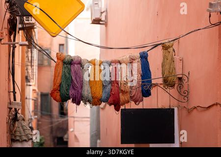 Lana tinta appesa nei suk di Marrakech, Morrocco. Piccola strada nella medina di Marrakech (città vecchia). Filati di lana tinti naturalmente. Foto Stock