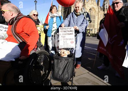 Londra, Regno Unito. 26 novembre 2025. Disability Rights UK sta organizzando una giornata di azione su College Green, Westminster, in coincidenza con il bilancio autunnale del governo, protestando contro i tagli e le sanzioni previsti per i benefici per la disabilità e il benessere. La dimostrazione esorta il governo a "tagliare le sanzioni non i benefici”, sottolineando l'impatto negativo che una condizionalità più rigorosa e un sostegno ridotto avranno sui disabili, sulle famiglie a basso reddito e sui lavoratori poveri. Crediti: Joao Daniel Pereira/Alamy Live News Foto Stock