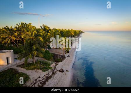 Il sole sorge sulla penisola dello Yucatan e sul Golfo del Messico, dipingendo il cielo in vivaci tonalità. Le acque calme e colorate risplendono sotto, creando una serena e confortante mattinata tropicale. Foto Stock