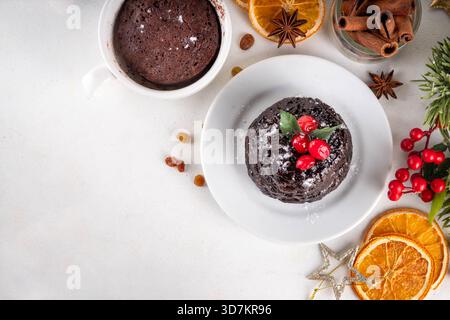 Tradizionale torta inglese di budino natalizio. Semplice idea di ricetta per il budino di Natale, preparata su tazza da tè con forno a microonde, con porzioni di budino di Natale Foto Stock
