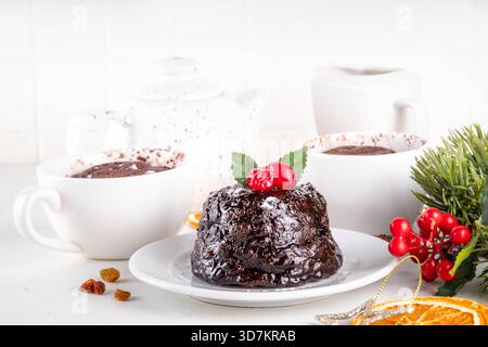 Tradizionale torta inglese di budino natalizio. Semplice idea di ricetta per il budino di Natale, preparata su tazza da tè con forno a microonde, con porzioni di budino di Natale Foto Stock