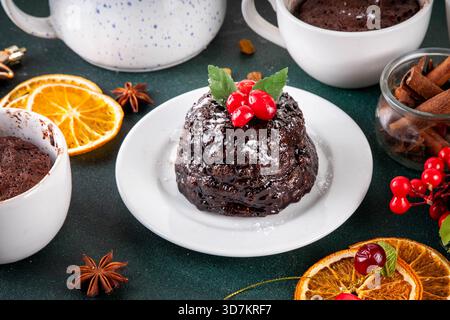 Tradizionale torta inglese di budino natalizio. Semplice idea di ricetta per il budino di Natale, preparata su tazza da tè con forno a microonde, con porzioni di budino di Natale Foto Stock