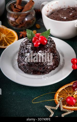 Tradizionale torta inglese di budino natalizio. Semplice idea di ricetta per il budino di Natale, preparata su tazza da tè con forno a microonde, con porzioni di budino di Natale Foto Stock