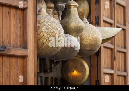 Le tradizionali lampade a sospensione in ottone marocchino si illuminano con intricati motivi trafilati in un suk di Marrakech. Lanterne in metallo marocchino realizzate a mano. Foto Stock
