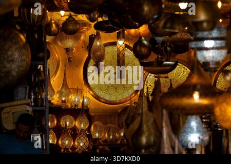 Le tradizionali lampade a sospensione in ottone marocchino si illuminano con intricati motivi trafilati in un suk di Marrakech. Lanterne in metallo marocchino realizzate a mano. Foto Stock