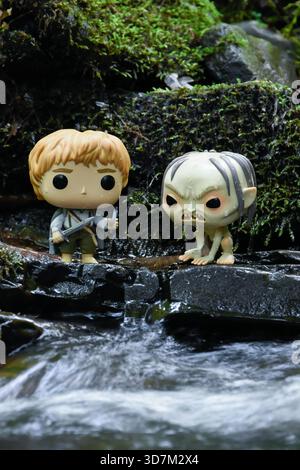 Funko Pop action figure di Sam e Gollum dal film il Signore degli anelli. Pietre umide mossy, acqua di ruscello schiumosa. Foto Stock