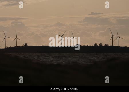Turbine eoliche all'orizzonte al tramonto Foto Stock