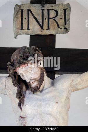 Cherasco, Italia - 10-20-2025: Scultura del volto di Gesù Cristo crocifisso sulla croce con la corona di spine. Foto Stock