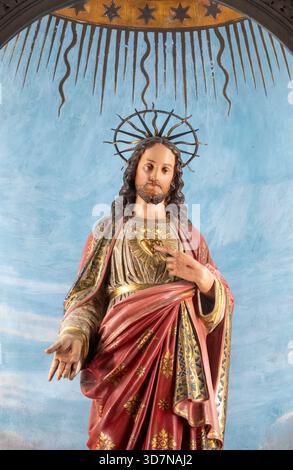 Cherasco, Italia - 10-20-2025: Statua colorata (XIX secolo) del Sacro cuore di Gesù Cristo. Foto Stock