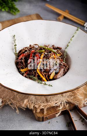 Spaghetti di manzo dal sapore audace con peperoni croccanti e semi di sesamo Foto Stock