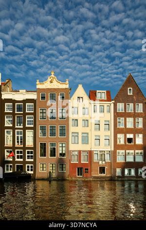 Architettura classica di Amsterdam: Case colorate sui canali con tradizionali trampolini Foto Stock