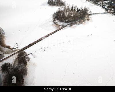 Vista aerea di un tranquillo paesaggio innevato con un ponte che collega un'isola, una scena invernale che evoca tranquillità, Trakai, Trakai, lituana Foto Stock