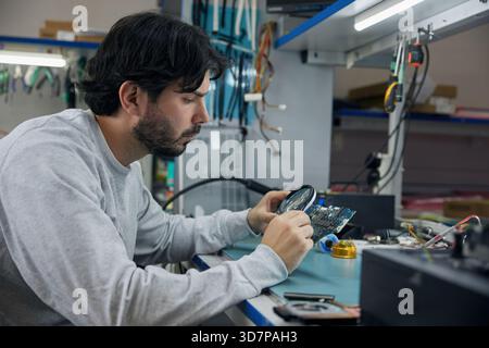 Un uomo sta lavorando a un progetto di dispositivi elettronici Foto Stock