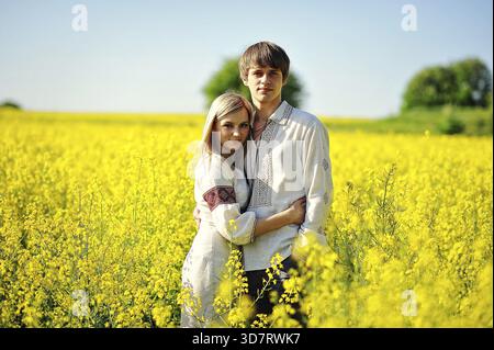 Coppia in abito tradizionale a fiori gialli campo Foto Stock