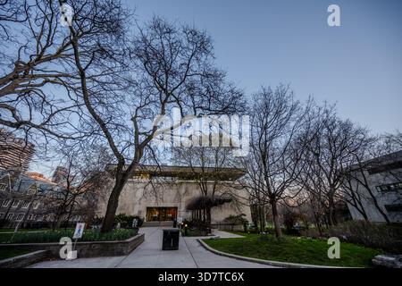 L'ingresso principale della Robarts Library, l'iconica struttura brutalista di Toronto, è visibile al crepuscolo attraverso alberi primaverili senza foglie dell'Università di Toro Foto Stock