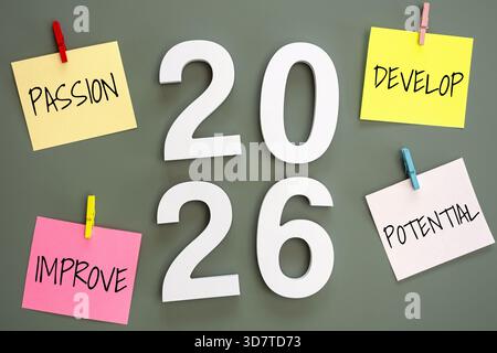 4 graffette post-it su una lavagna verde con il numero 2026 al centro e parola passione, sviluppo, miglioramento, potenziale intorno. obiettivo per il nuovo anno Foto Stock