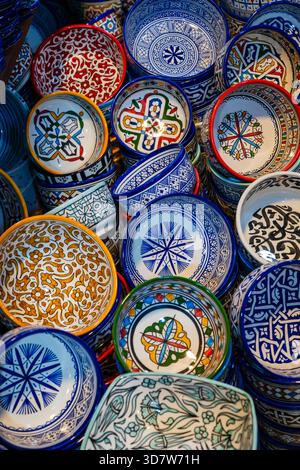 Colorato assortimento di piatti e ciotole in ceramica con fantasie complesse sovrapposte. Fez, Fez-Meknes, Marocco settentrionale Foto Stock