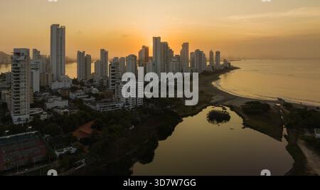 Alti edifici cittadini lungo la costa al tramonto con un calmo specchio d'acqua nelle vicinanze. Cartagena, Colombia Foto Stock