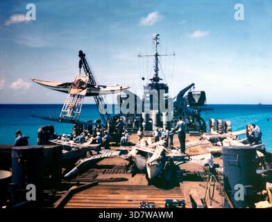 Uno stabilizzatore bikini nativo viene fatto oscillare a bordo della nave da sbarco LST-1108 della Marina degli Stati Uniti presso l'atollo di Bikini, nel marzo 1946. La popolazione indigena dell'atollo di Bikini è stata trasferita dalle autorità statunitensi all'atollo di Rongerik dal 7 marzo 1946 al 14 marzo mentre il governo degli Stati Uniti ha condotto i test nucleari "operazione Crossroads". Dopo mesi di carenza di cibo e malnutrizione, furono spostati prima a Kwajalein e infine a Kili Island. Il 1° marzo 1954, Rongerik fu esposto a ricadute radioattive a seguito della detonazione dell'operazione Castle Bravo. Marzo 1946 Foto Stock