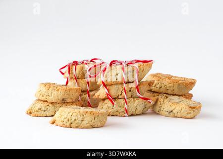 Biscotti tradizionali della Toscana - cantucci (cantuccini) o biscotti con mandorle decorati con nastro rosso-bianco su sfondo bianco. Foto Stock