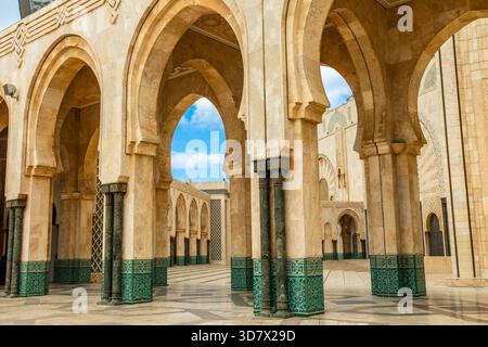Colonnato ad arco della Moschea di Hassan II a Casablanca, Marocco, con pilastri in pietra, dettagli geometrici e design architettonico islamico tradizionale Foto Stock