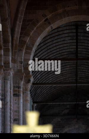 Archi in pietra romanica e soffitto a volta in legno all'interno dell'Abbazia di Mont Saint-Michel. Architettura romanica storica con colonne imponenti. Foto Stock