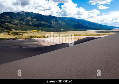 Montagna verde e dune di sabbia in primo piano Foto Stock