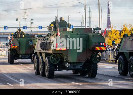 Veicoli militari corazzati alleati della NATO 8x8 che guidano lungo una strada urbana con soldati posizionati sulla parte superiore, placcatura mimetica e attrezzature montate durante Foto Stock