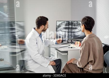 Consulenza odontoiatrica paziente durante la revisione dei raggi X dentali Foto Stock