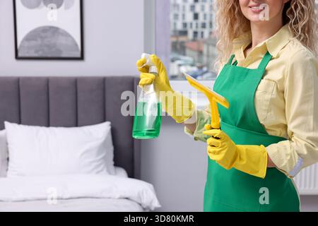Finestra di pulizia. Donna con spatola e detergente in casa, primo piano. Spazio per il testo Foto Stock