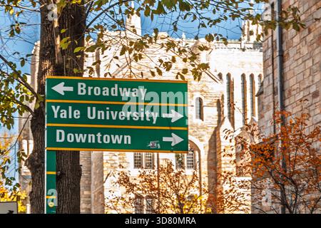 Un cartello verde indica i percorsi per la Yale University, Broadway e il centro città, circondato da edifici storici a New Haven, Connecticut. Foto Stock
