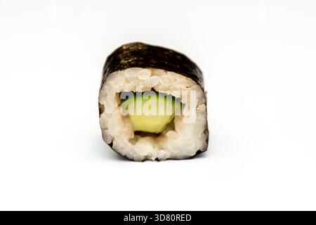 Il rotolo di avocado giace su una superficie bianca, rivelando la consistenza del riso e dei nori Foto Stock