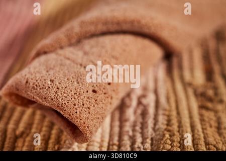Un pezzo arrotolato di injera, la focaccia etiope a base di teff, una farina locale Foto Stock