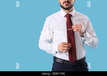 Giovane uomo d'affari con cravatta su sfondo blu Foto Stock