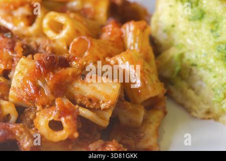 La pasta alla bolognese si scioglie con il primo piano del pane all'aglio Foto Stock