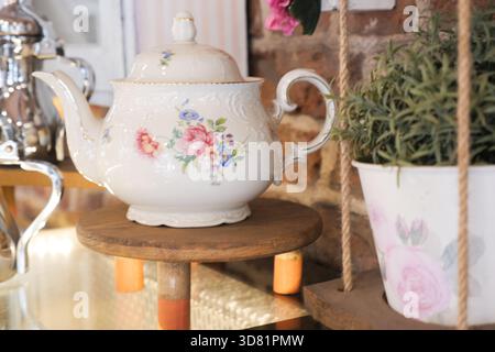 Splendida teiera vintage in mostra in un accogliente ambiente da caffetteria Foto Stock