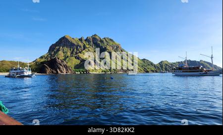 Maestosa Green Island nel tranquillo Oceano con barche Foto Stock