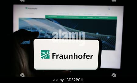 In questa illustrazione fotografica, una persona ha in mano un cellulare con il logo dell'organizzazione di ricerca Fraunhofer-Gesellschaft sullo schermo davanti alla pagina web. (Foto di Timon Schneider / SOPA Images/Sipa USA) *** esclusivamente per notizie editoriali *** Foto Stock