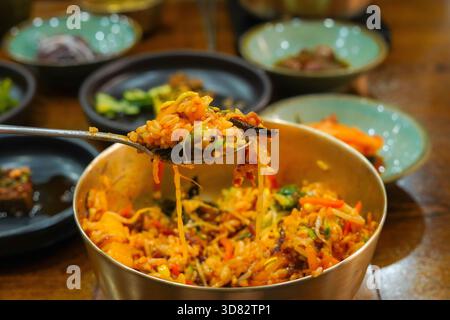 Delizioso Bibimbap in stile Jeonju, miscelato in una tradizionale ciotola in ottone coreano Foto Stock