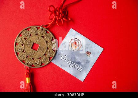 Carta Zodiac Dragon cinese con moneta tradizionale su sfondo rosso Foto Stock