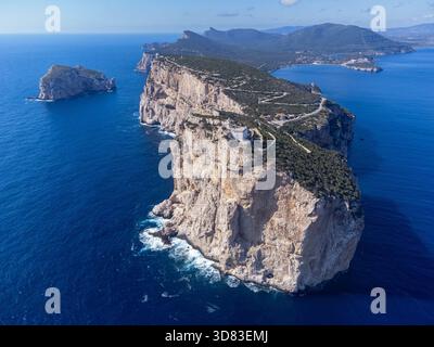Splendida vista aerea del promontorio di Capo caccia in Sardegna, Italia. L'iconico faro bianco si trova in cima alla scogliera calcarea a strapiombo, dramatica Foto Stock