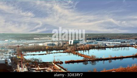 Paesaggio urbano visto dall'alto, caratterizzato da architettura industriale, edifici moderni, serbatoi d'acqua multipli e cantieri attivi Foto Stock