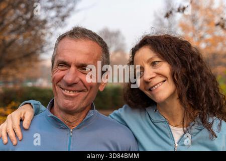 Coppia di mezza età che sorride all'aperto indossando abbigliamento sportivo Foto Stock