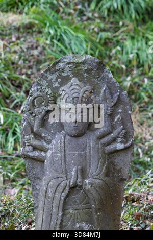 Piccola placca scultorea di Buddha con la figura di Murti, diversi volti e braccia che simboleggiano diversi poteri nel tempio Saigandenji nel piccolo villag Foto Stock
