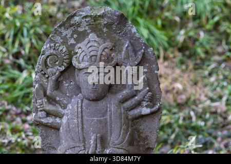 Piccola placca scultorea di Buddha con la figura di Murti, diversi volti e braccia che simboleggiano diversi poteri nel tempio Saigandenji nel piccolo villag Foto Stock
