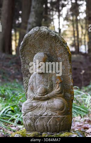 Piccola placca scultorea del Buddha Gautama ricoperta di licheni, tempio Saigandenji nel piccolo villaggio di Aso Kumamoto, in Giappone Foto Stock